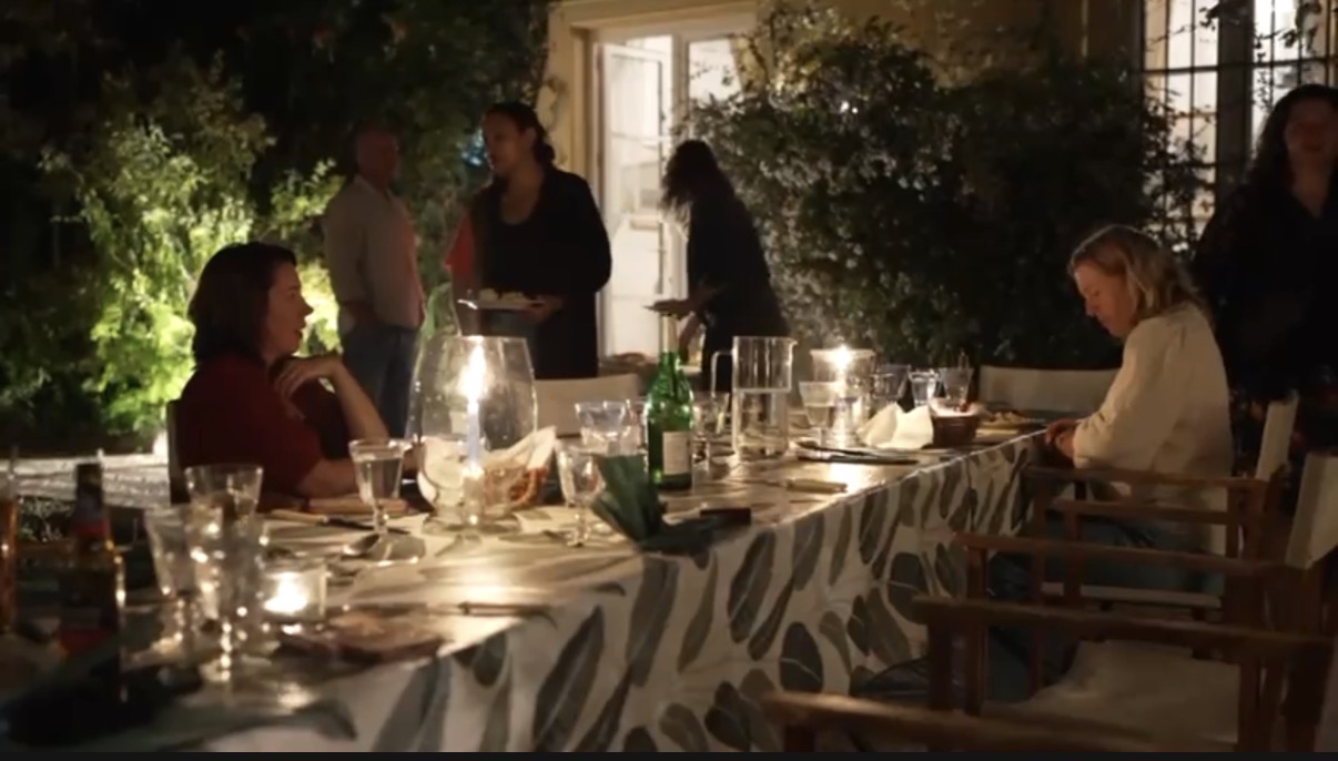 Diner bij kaarslicht aan de lange gedekte tafel